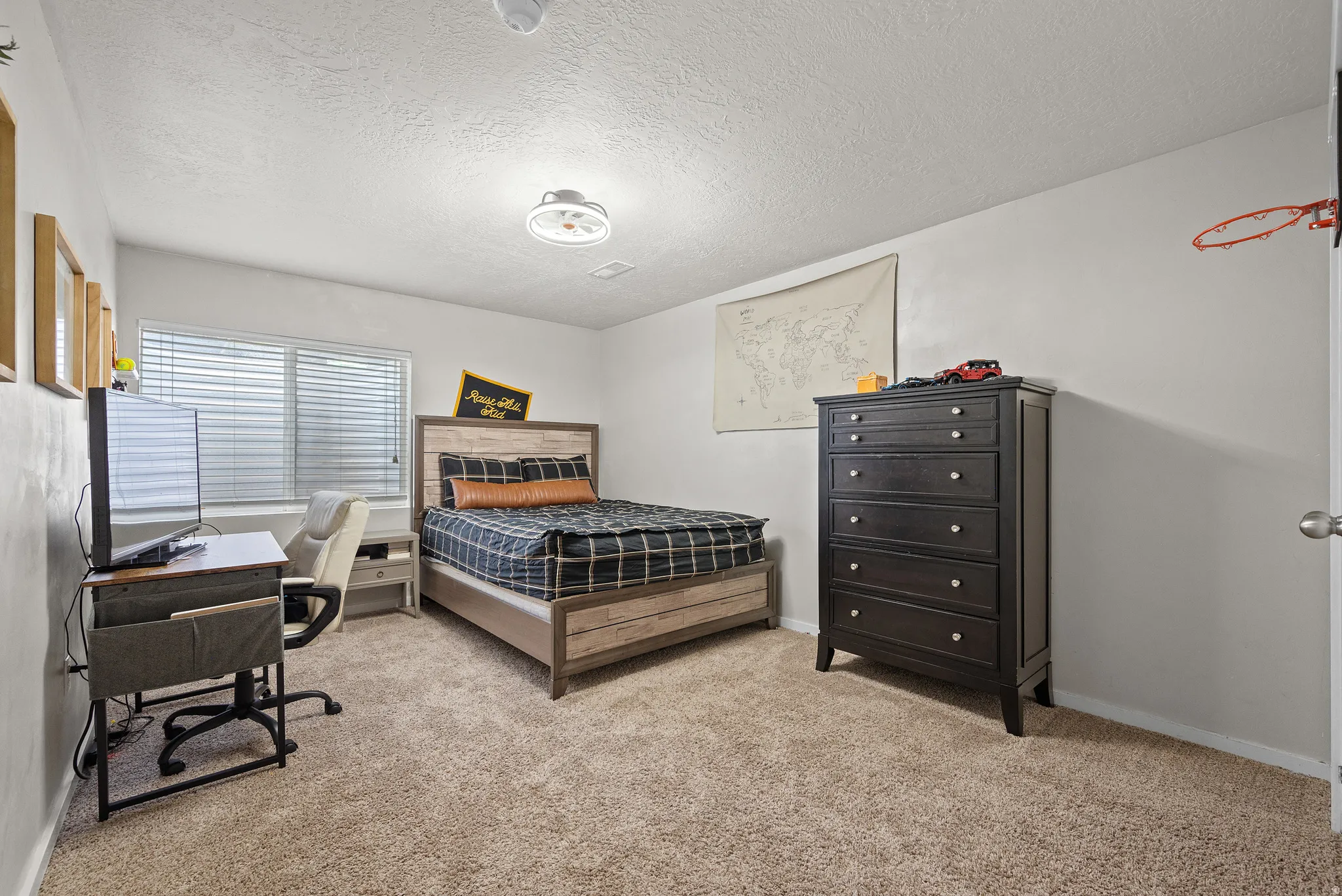 Carpeted bedroom featuring white walls and a ceiling fan with integrated lighting