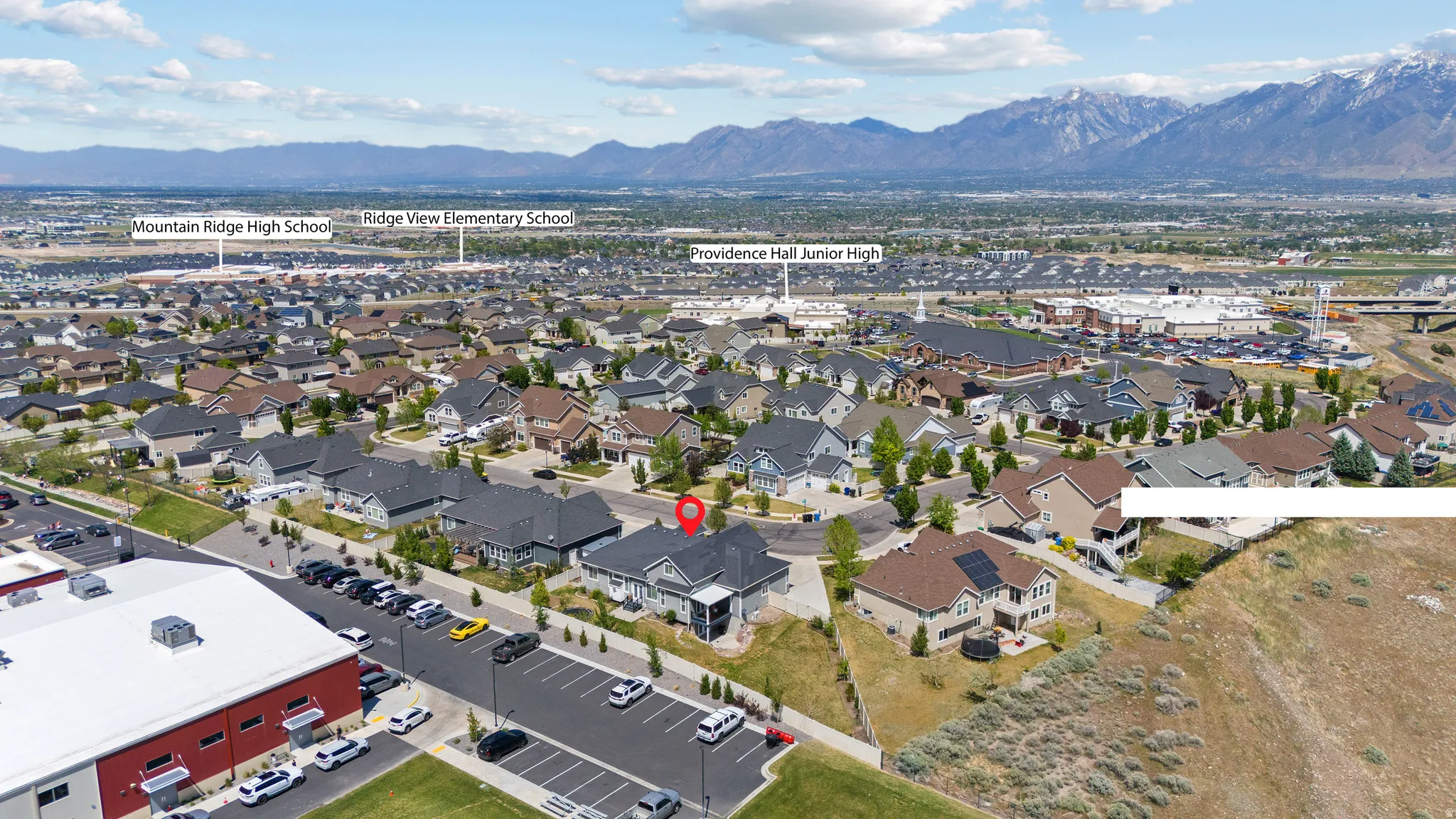 Aerial view showcasing a residential neighborhood with mountain backdrops