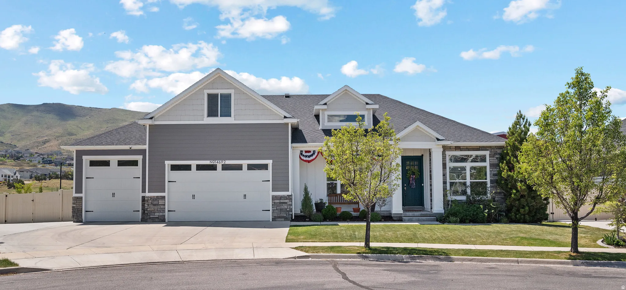Contemporary ranch-style residence featuring a two-car garage, an additional single-car garage, and stone accents