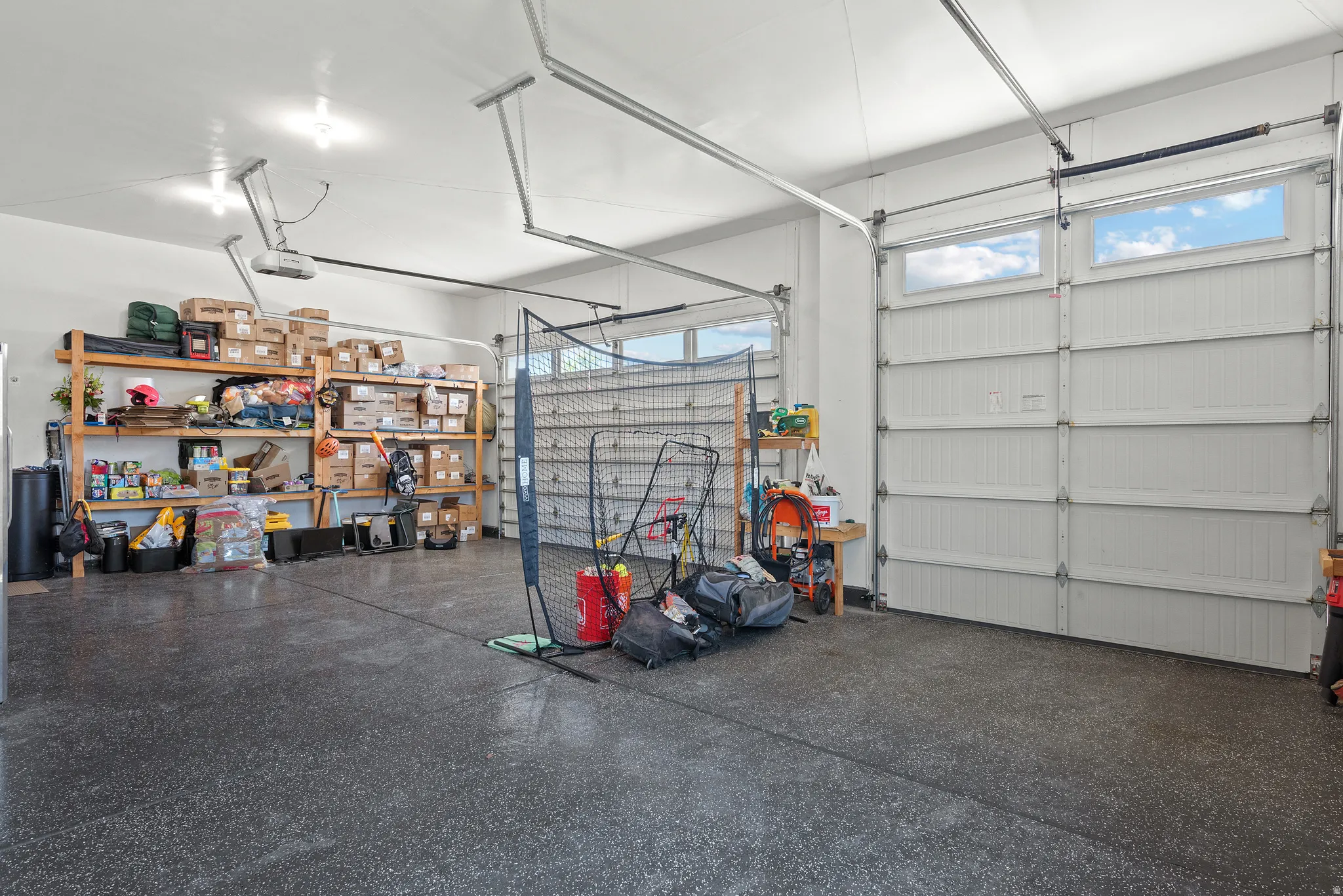 Two-car garage featuring a speckled epoxy floor and bright overhead lighting
