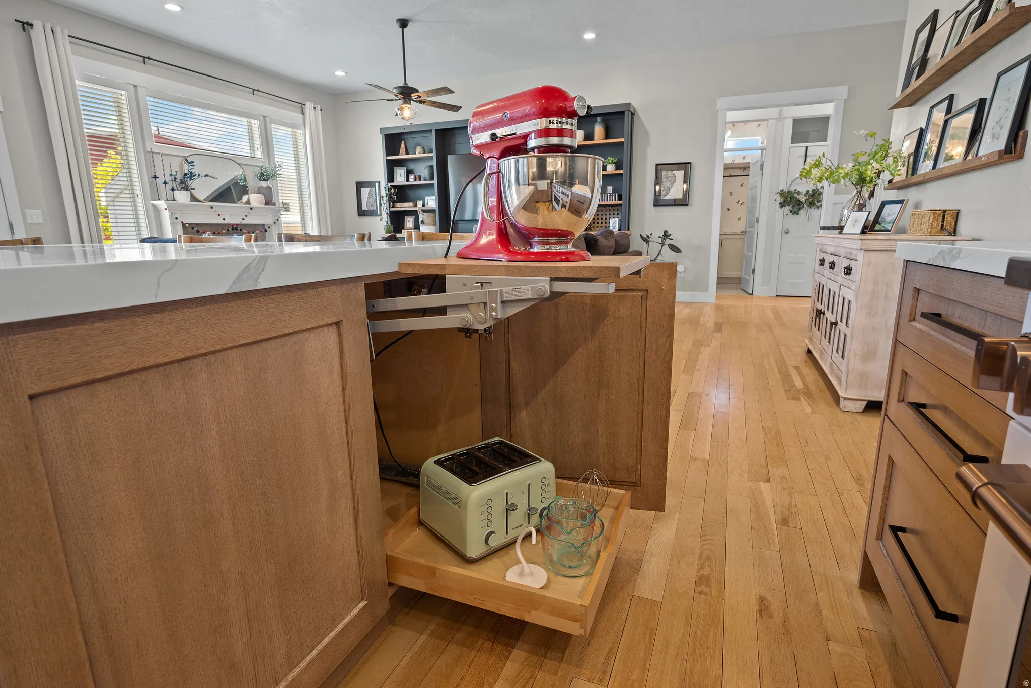 Kitchen island featuring a pull-out appliance shelf, wood-finish cabinetry, and a light-toned countertop