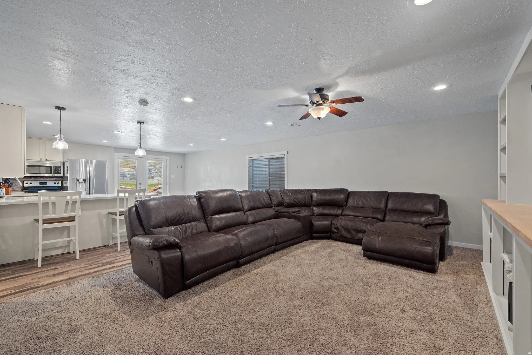Open-concept living area featuring recessed lighting, a ceiling fan, and wood-finish flooring