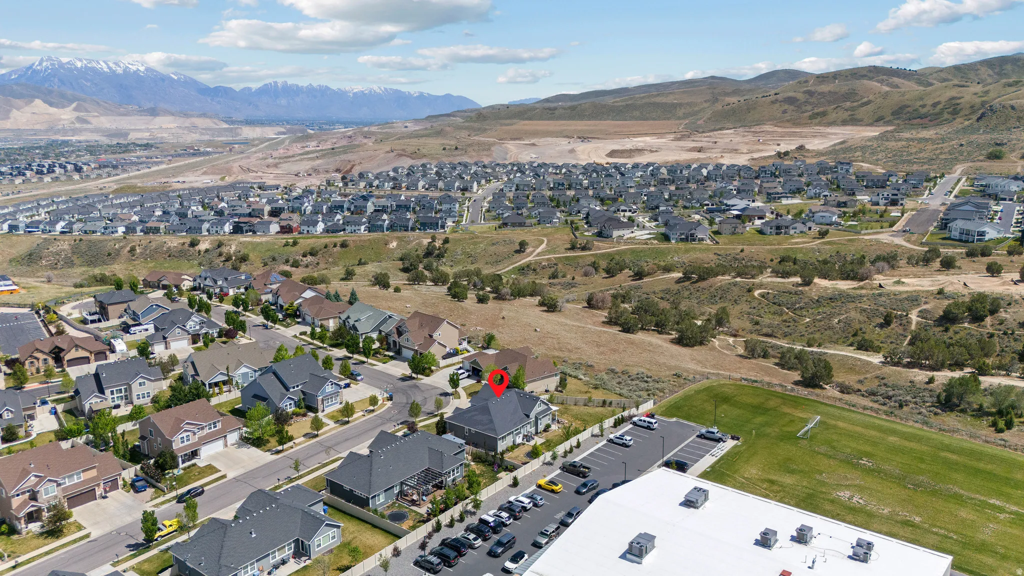 Aerial perspective showcasing a residential community with contemporary homes, featuring mountains as a distant backdrop