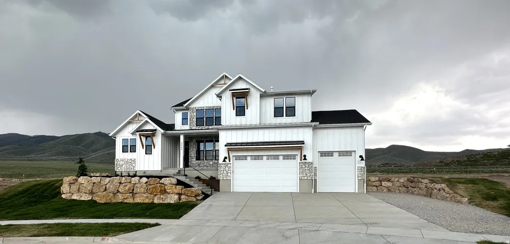 Modern farmhouse-style residence featuring white siding and stonework accents