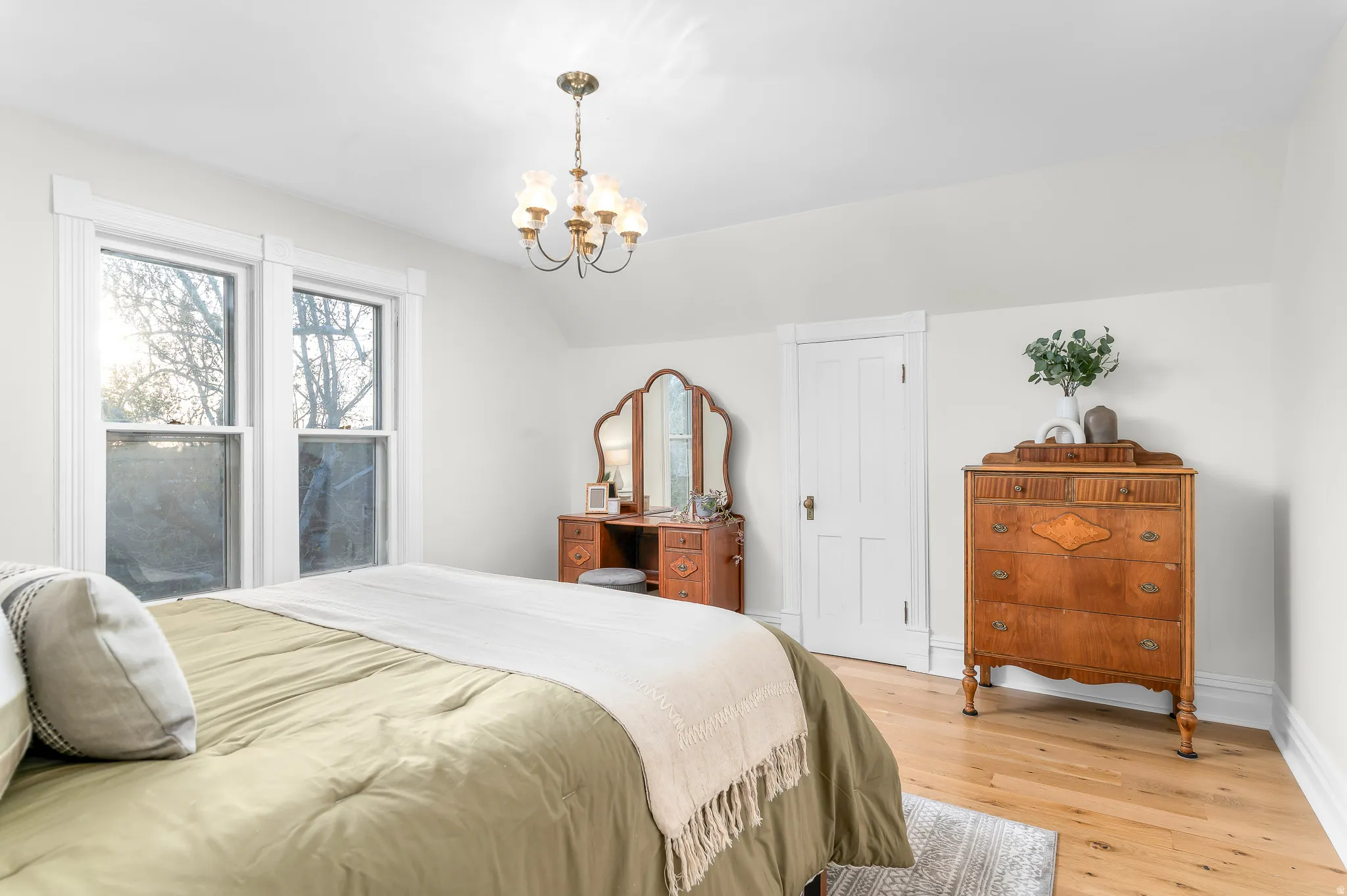 Bedroom featuring light-tone wood-finish flooring, white walls, and white trim