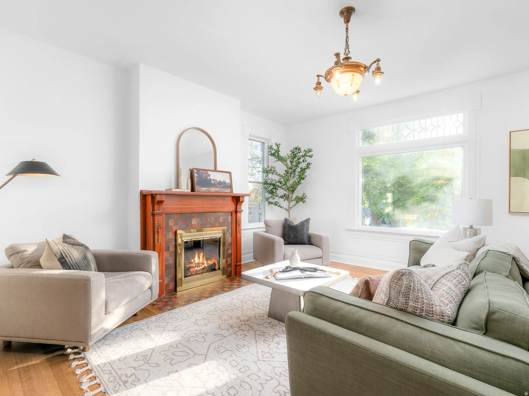 Living area with a detailed fireplace mantel featuring a brass-framed firebox