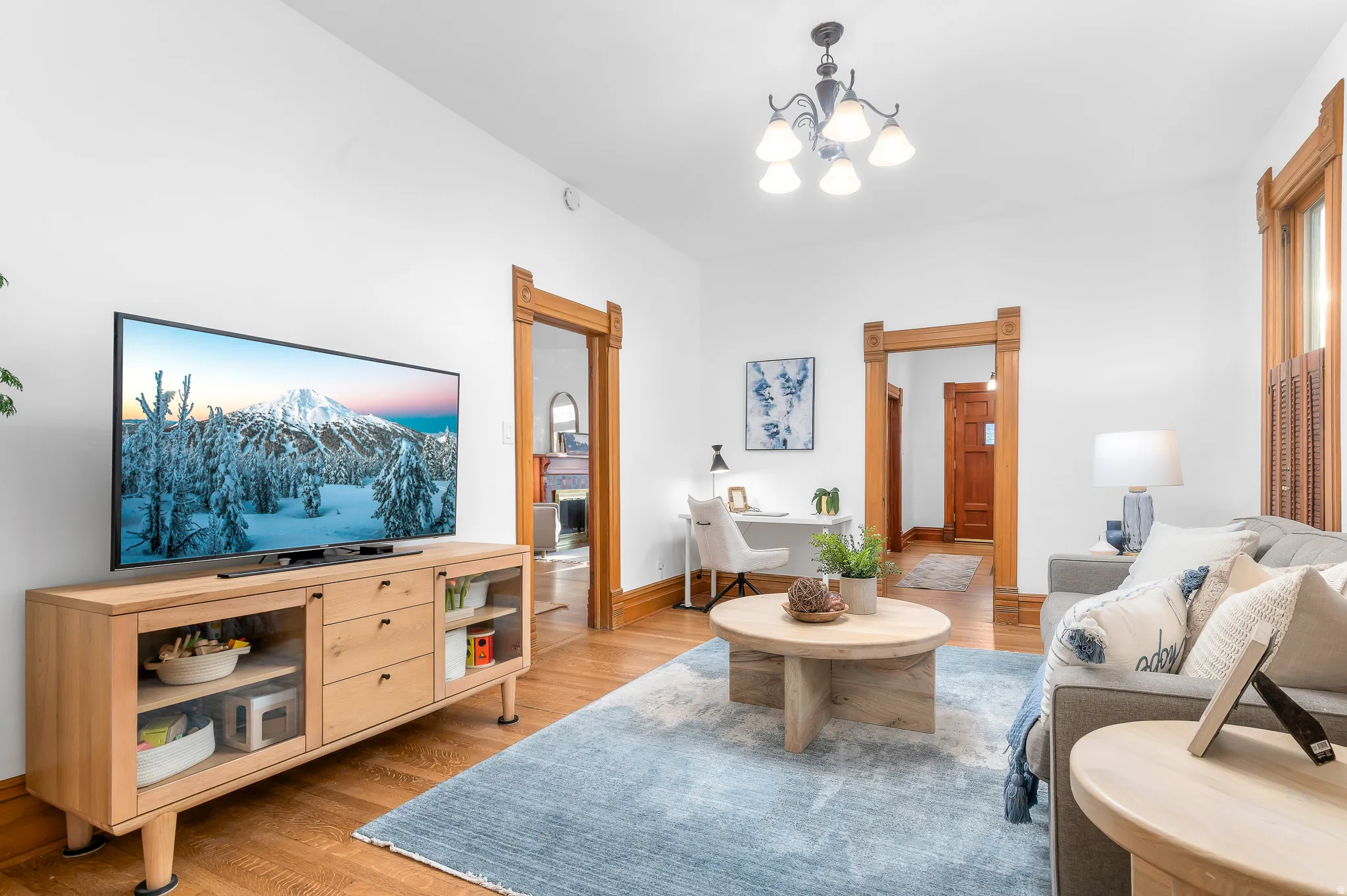 Living area featuring wood-finish flooring, white walls, and substantial wood door frames