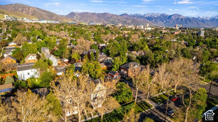 Established neighborhood with mature trees, diverse architectural styles, and distant mountain ranges