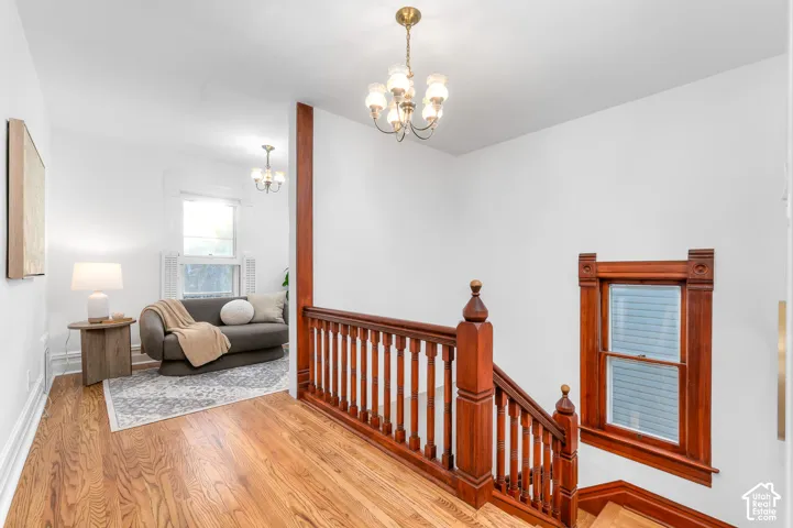 Hardwood flooring extends throughout this upper level, complementing the stained wood staircase and custom window trim