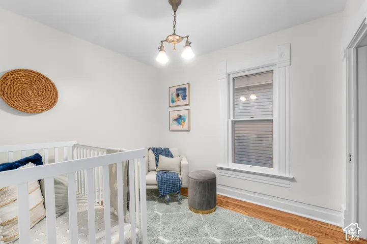 Hardwood flooring, ornate window trim, ceiling-mounted light fixture, white walls, and a white door frame