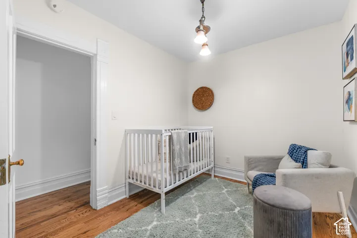 Hardwood flooring, crisp white walls, detailed door trim, ceiling-mounted light fixture