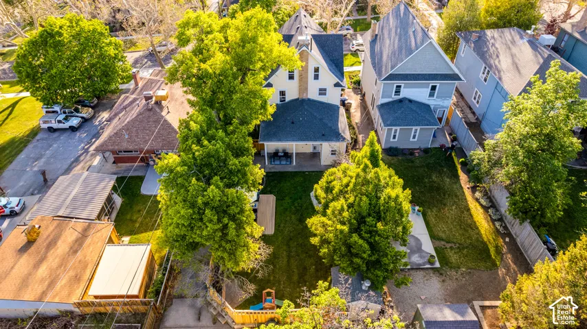 Expansive backyard featuring a manicured lawn, mature trees, and a wooden fence