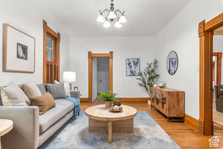 Hardwood flooring throughout, detailed wood trim, elegant chandelier, and expansive wall space