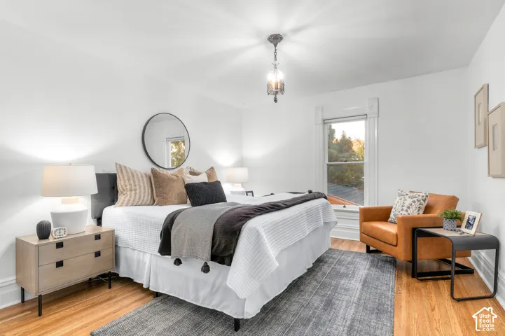 Hardwood flooring, classic window trim, overhead chandelier, and a built-in wall mirror