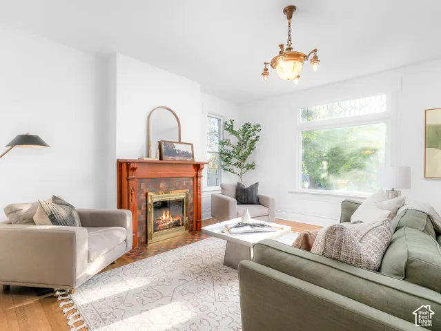 Living area with a detailed fireplace mantel featuring a brass-framed firebox