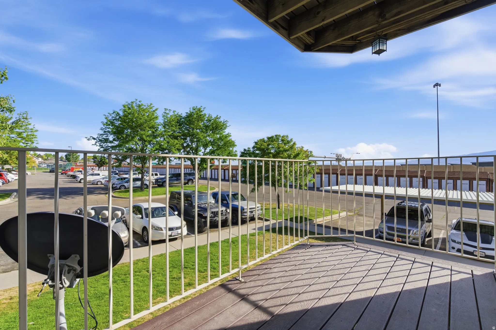 Outdoor balcony featuring wood-finish flooring and a white metal railing