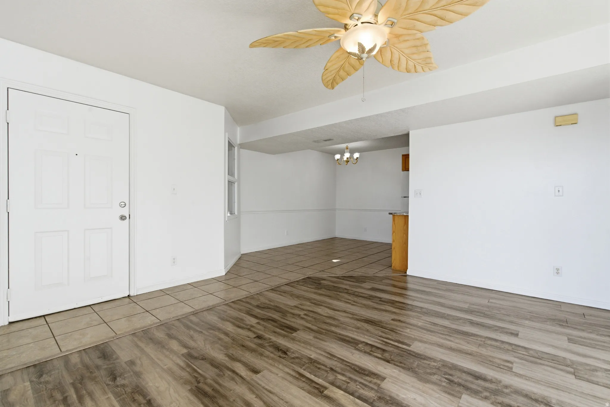 Entry area featuring wood-finish flooring transitioning to square tile