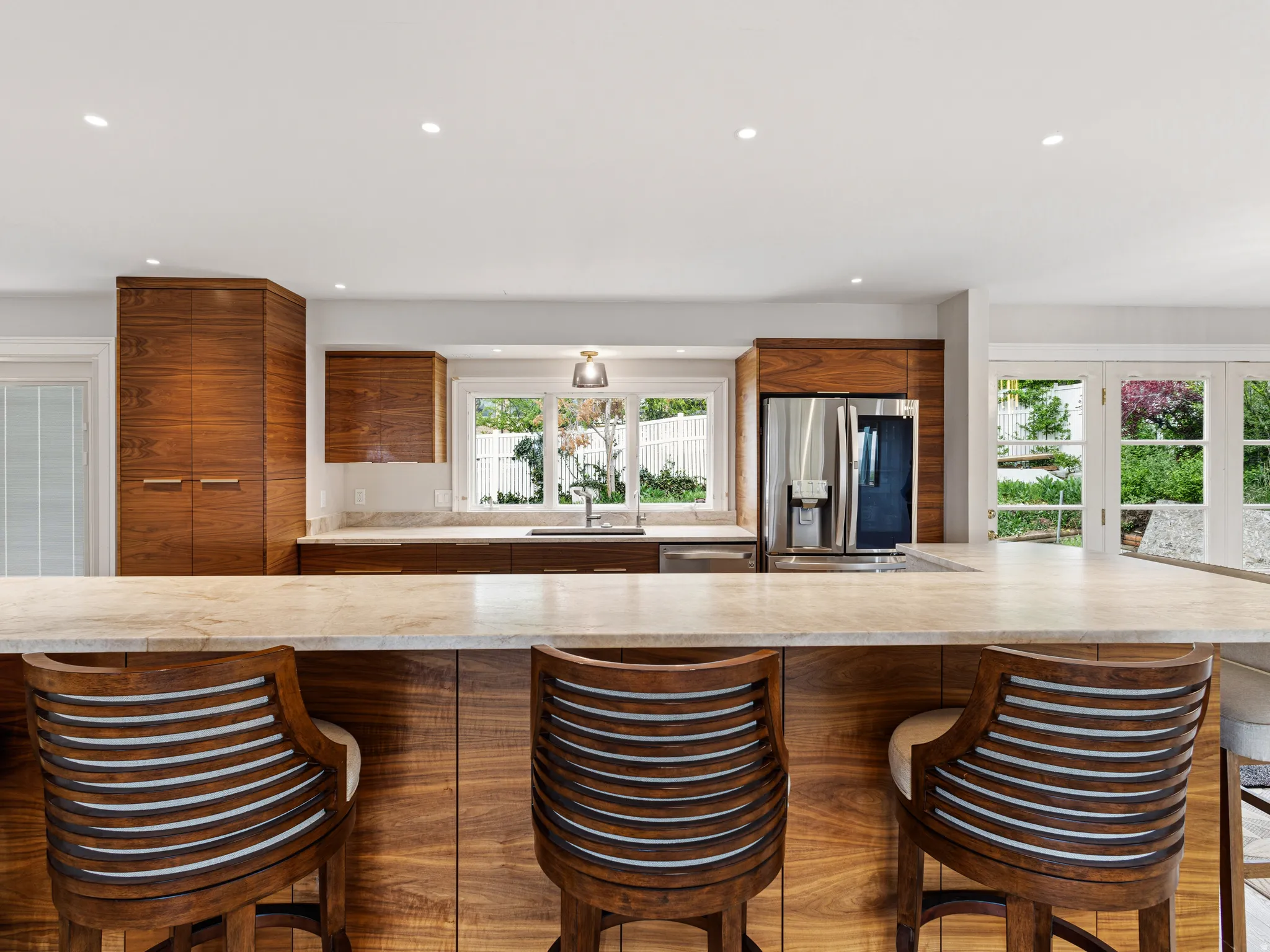 Kitchen featuring an expansive countertop island, wood-finish cabinetry, recessed lighting, and stainless steel appliances