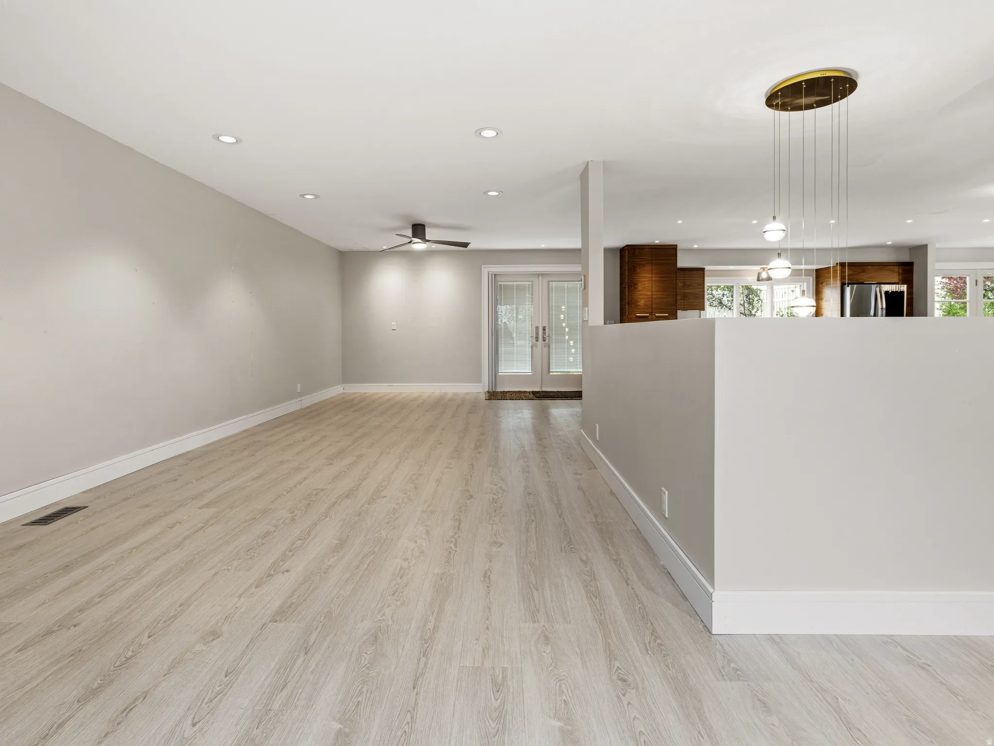 Spacious interior featuring wood-finish flooring, recessed lighting, and a contemporary ceiling fan