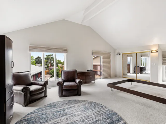 Vaulted ceilings highlight this expansive room featuring carpet flooring