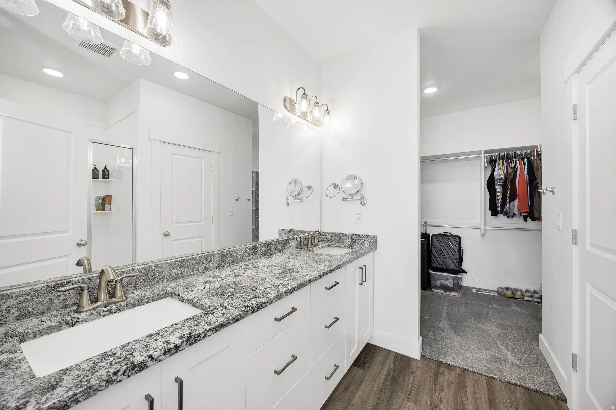 Dual vanity with undermount sinks, stone countertop, and brushed nickel fixtures
