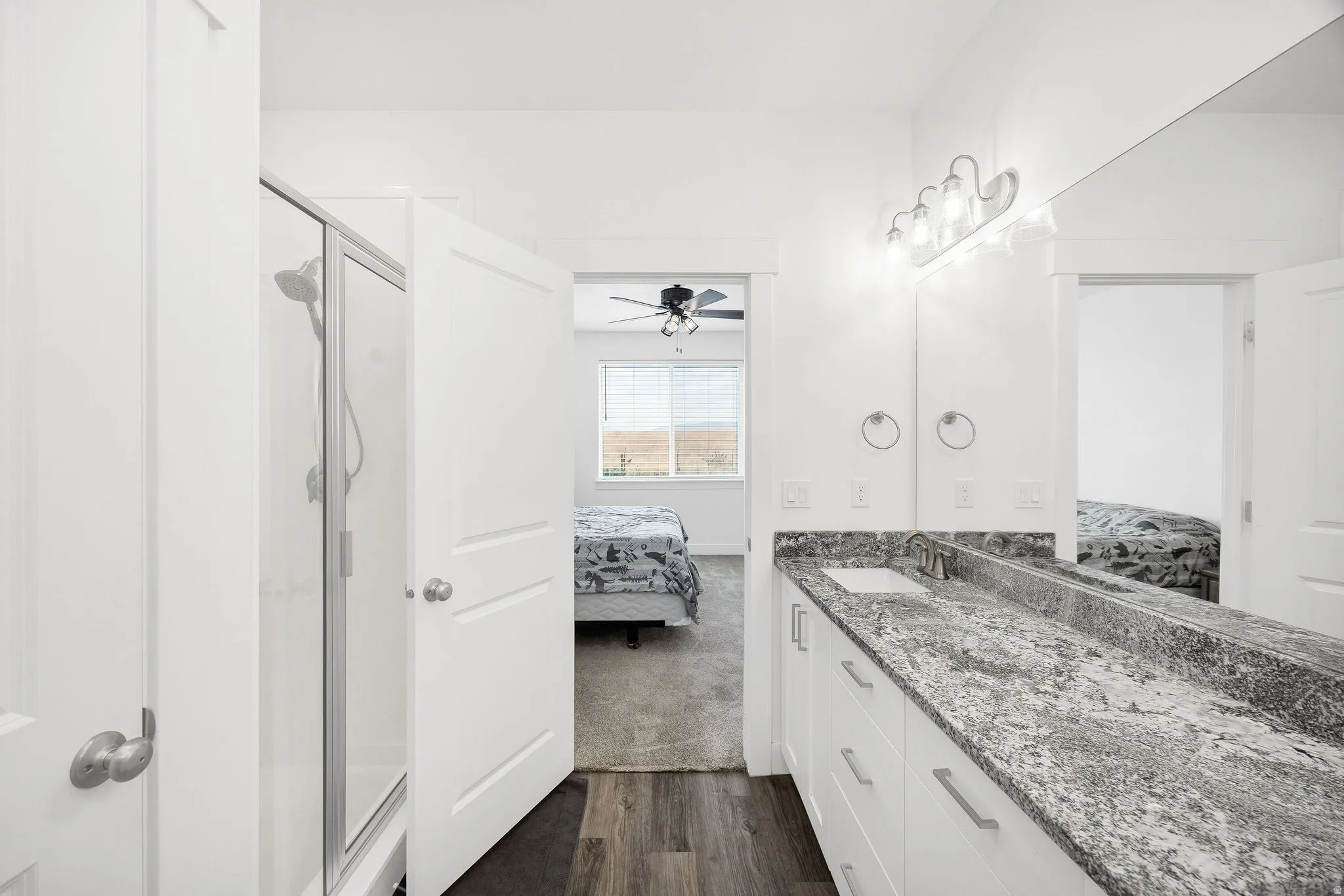 Bathroom featuring a double vanity with stone countertop, white cabinetry, and brushed nickel hardware