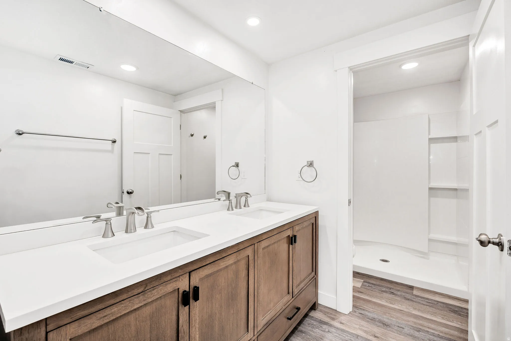 Double vanity with white countertops, undermount sinks, and brushed nickel fixtures