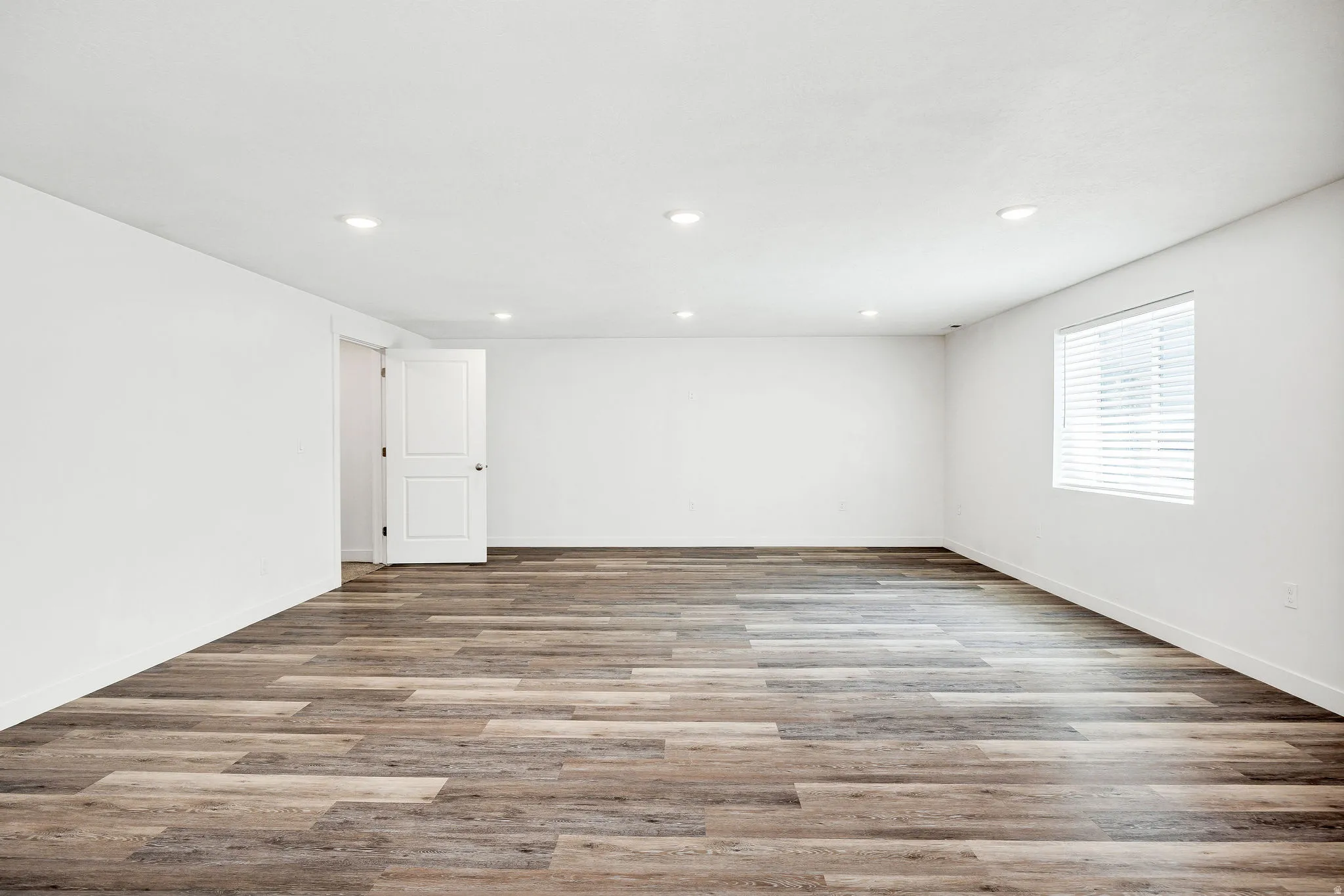 Spacious interior featuring wood-finish flooring and recessed lighting