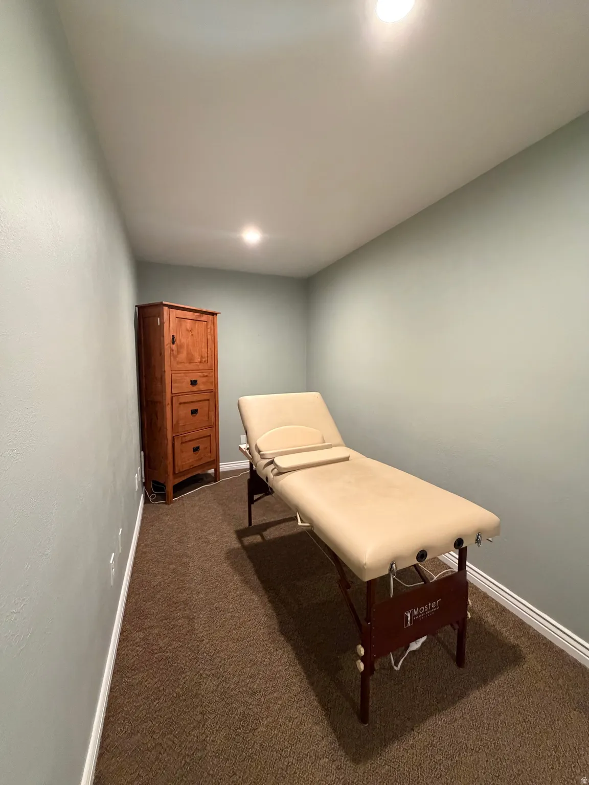 Room featuring light green painted walls, recessed lighting, brown carpet flooring, and white baseboards