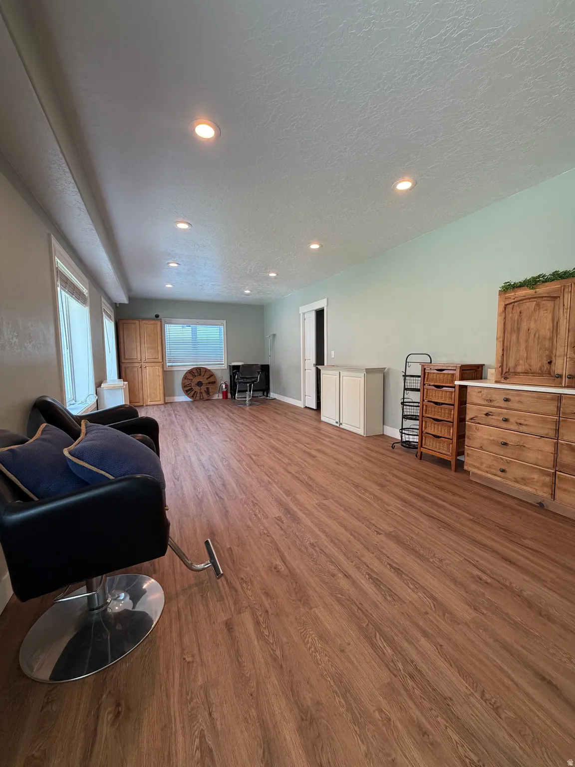 Spacious interior room featuring wood-finish flooring, recessed lighting, and light-toned walls