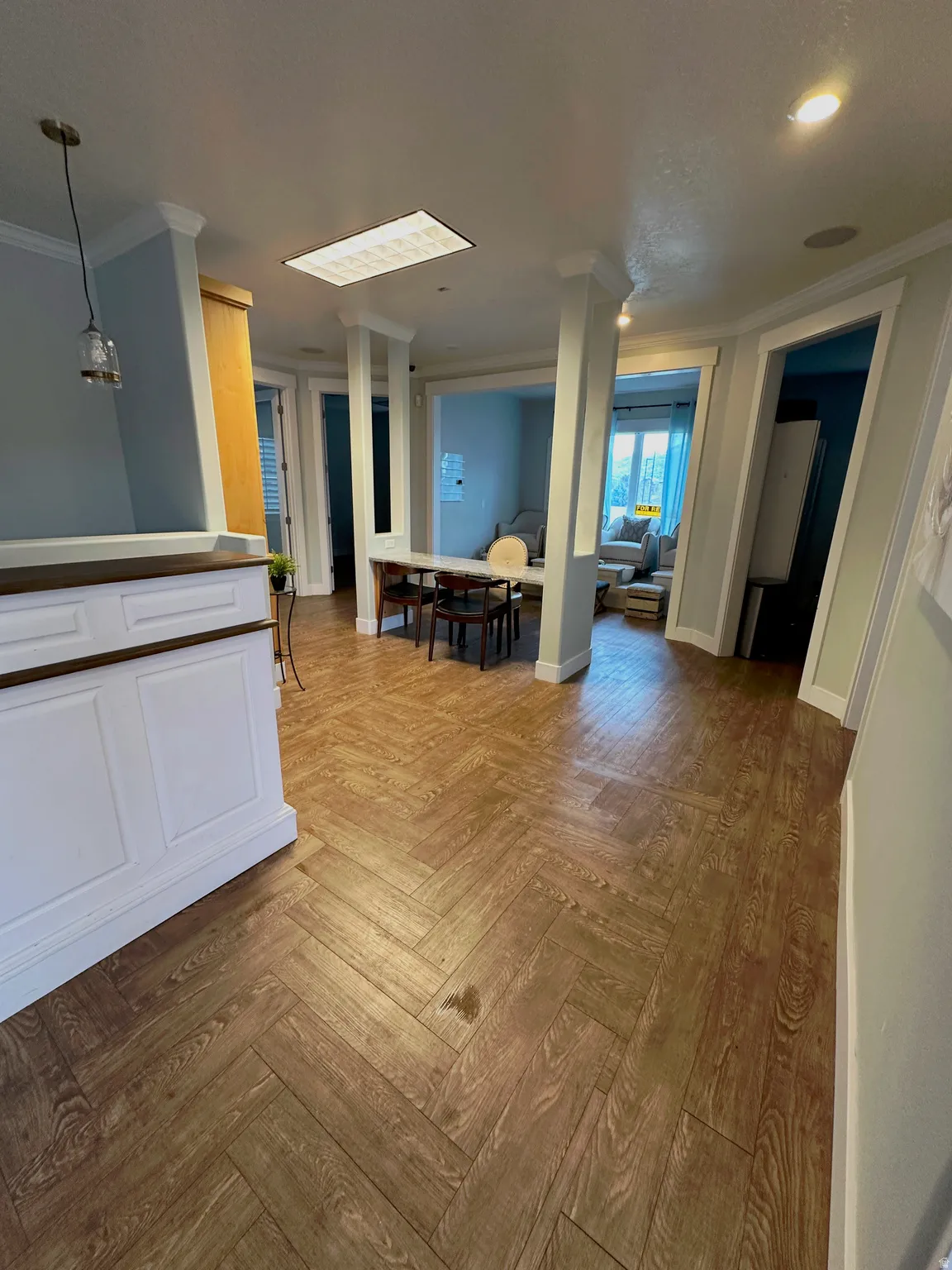Open concept interior featuring herringbone wood-finish flooring