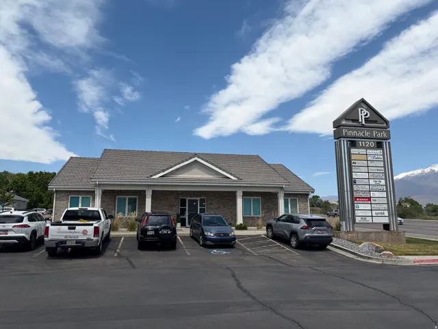 Commercial building featuring a brick facade, gabled roof, and columned entrance