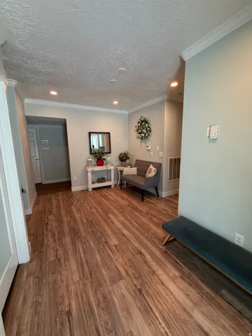 Wood-finish flooring throughout, complemented by recessed lighting and crown molding