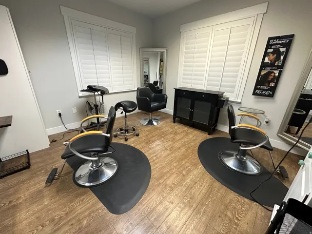 Spacious interior featuring wood-finish flooring and multiple windows with white plantation shutters