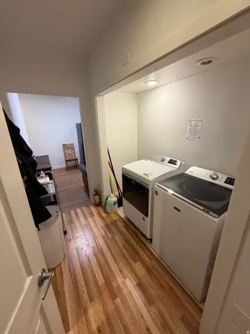 Dedicated laundry area with wood-finish flooring, recessed lighting, and white walls