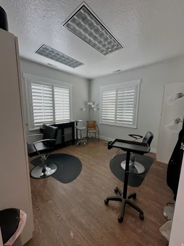 Room featuring wood-finish flooring, recessed lighting, and white plantation shutters on multiple windows