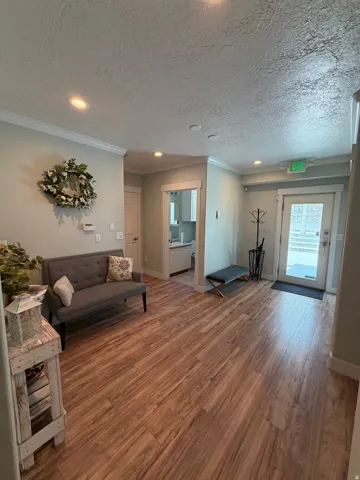 Spacious interior featuring wood-finish flooring, recessed lighting, and crown molding