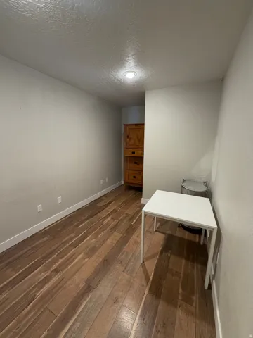 Room featuring wood-finish flooring, recessed ceiling lighting, and light-toned wall finishes