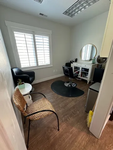Room featuring wood-finish flooring, white plantation shutters, and recessed fluorescent lighting