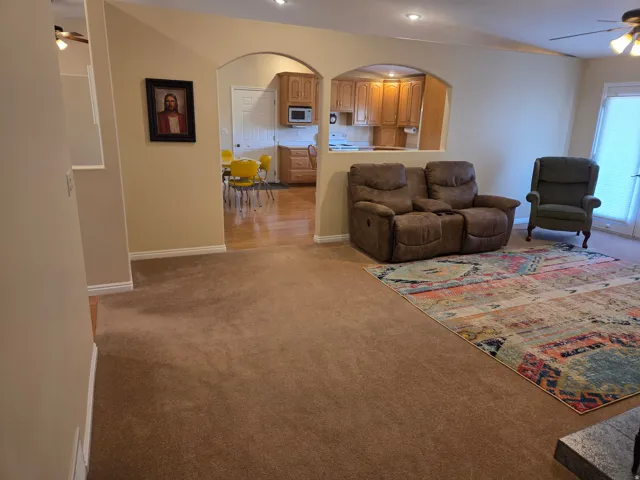Living area with recessed lighting, brown carpet flooring, and white baseboards