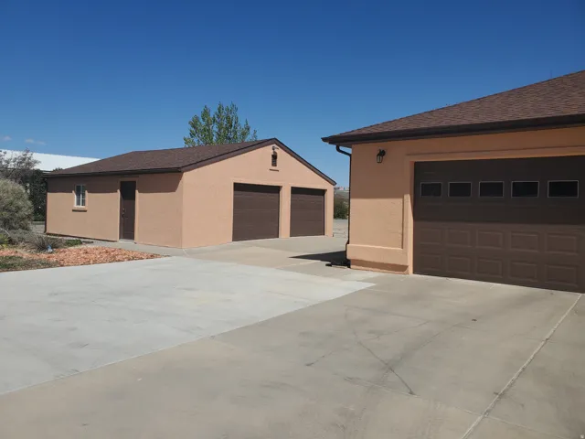 Two detached structures featuring stucco exteriors and asphalt shingle roofs