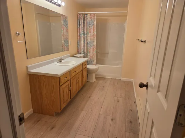 Bathroom featuring a wood-finish vanity with a white countertop and integrated sink