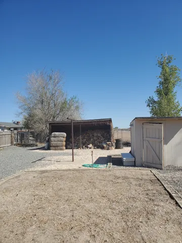 Expansive outdoor area featuring a gravel ground cover and a wooden fence