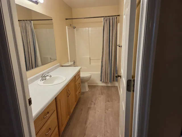 Bathroom featuring a single vanity with wood-finish cabinetry, a white countertop, and an integrated sink