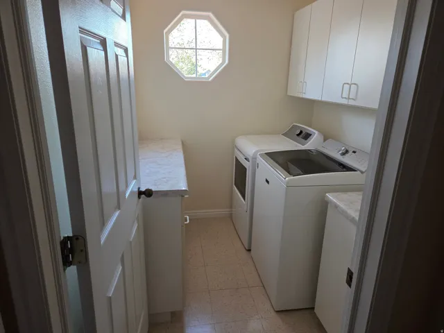 Dedicated utility space featuring a functional octagon window, wall-mounted cabinetry, and a countertop for workspace