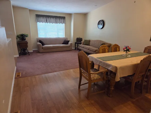 Open-concept floor plan featuring wood-finish flooring and soft carpeting