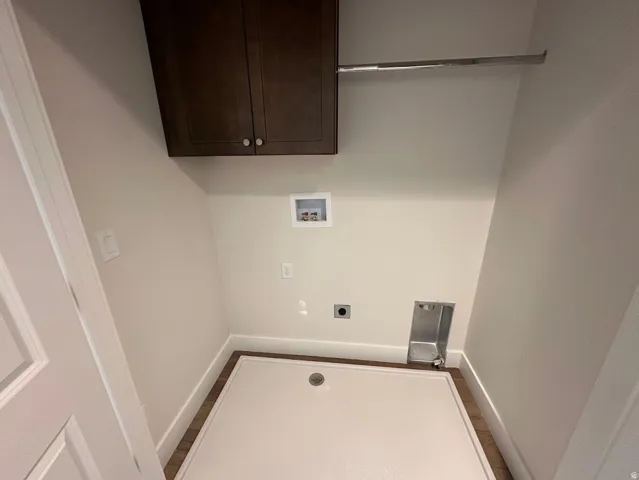 Dedicated laundry space with wood-finish flooring, white baseboards, and neutral wall paint