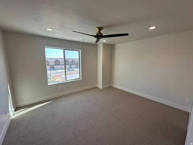 Spacious room featuring neutral carpeting and light-colored walls