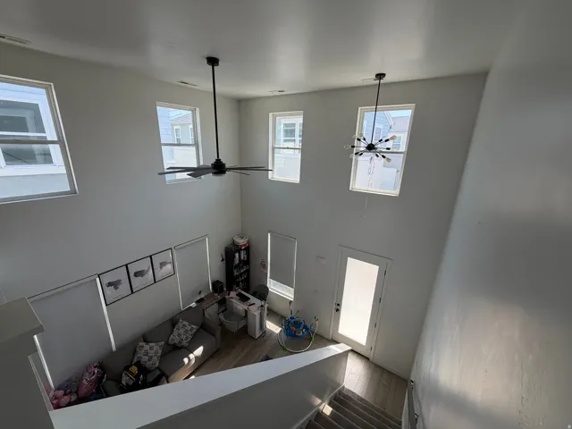 Two-story living area featuring high ceilings, multiple windows, recessed lighting, and wood-finish flooring