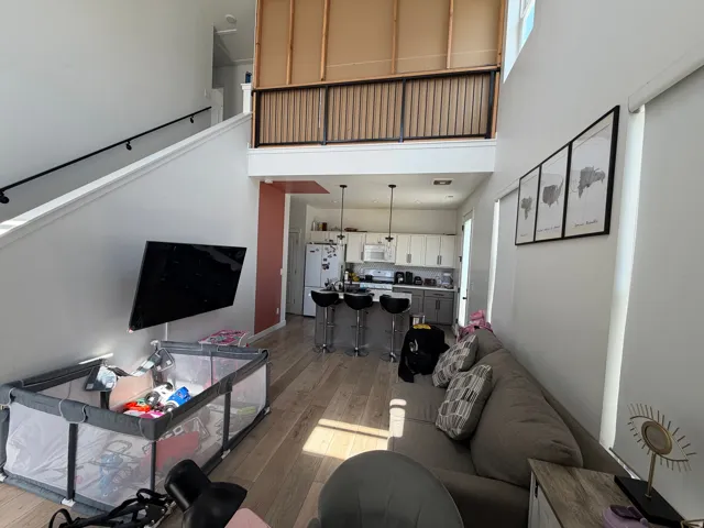 Open-concept living area featuring high ceilings and wood-finish flooring